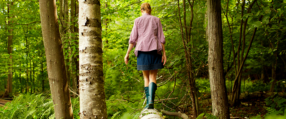 Naturprodukt-Shop, junge Frau Balanciert auf einem Baumstamm im Wald